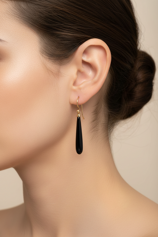 Close-up of a woman wearing a black onyx teardrop earring