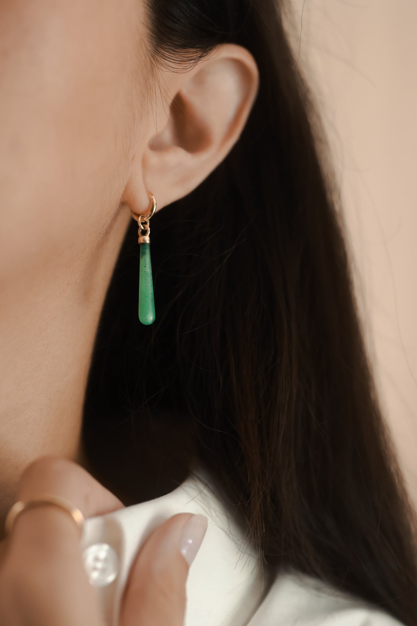 Green teardrop earrings on a model.