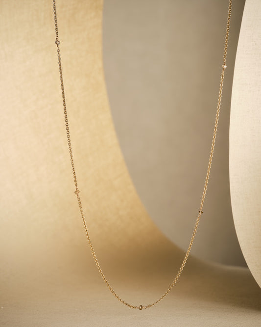 diamond bead sleeper necklace on beige background