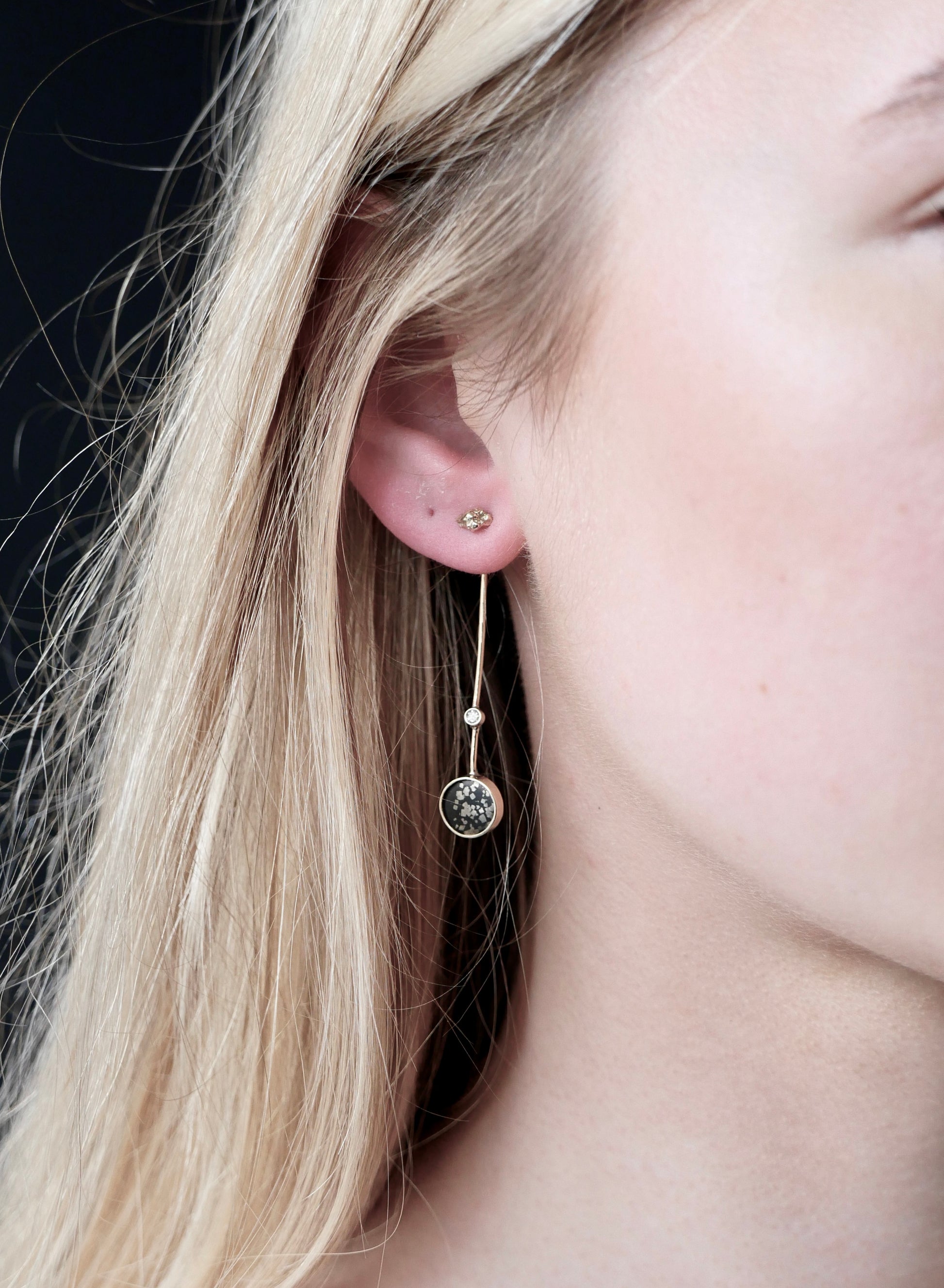 stellar black and gold diamond drop earrings on model