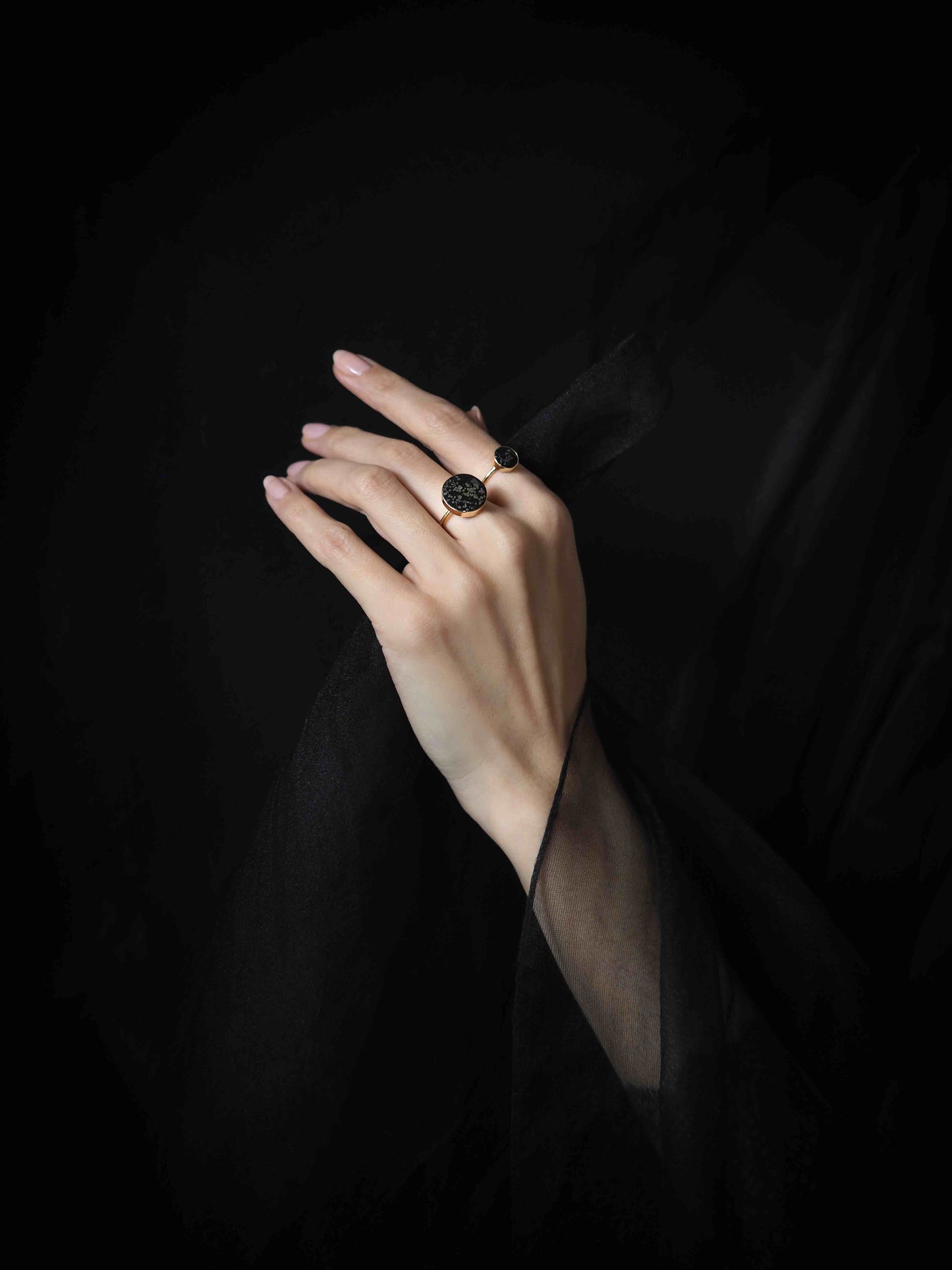 large black and gold cocktail ring on model