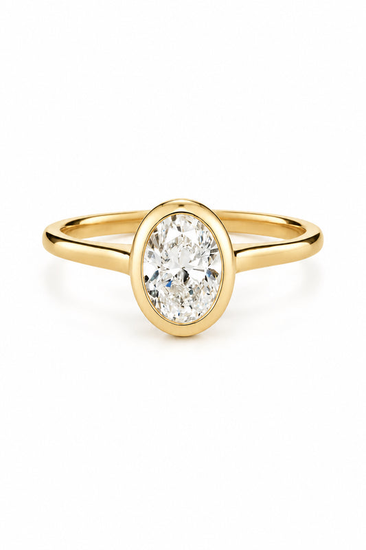 Oval cut diamond in rubover setting on simple band. Simple modern engagement ring. 0.75 ct diamond.
