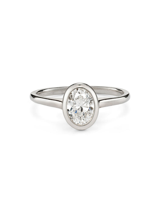 An oval diamond engagement ring in platinum or white gold with a simple bezel rubover setting.  0.75ct diamond.