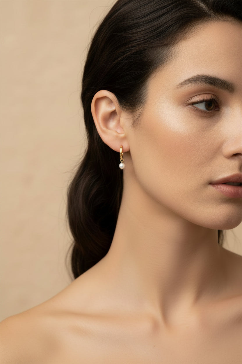 Square wire yellow gold hoops with hinge fastening and round pearl drops worn