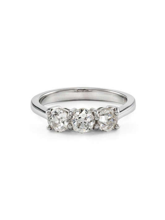 A three-stone diamond ring with a polished platinum band featuring three old mine cut diamonds set in a row, shown on a plain white background.
