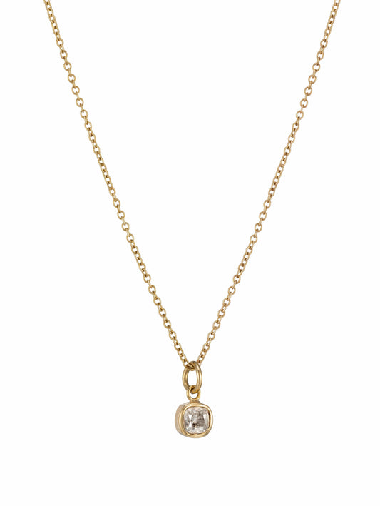 A delicate yellow gold chain necklace with a bezel-set cushion-cut salt and pepper grey diamond.