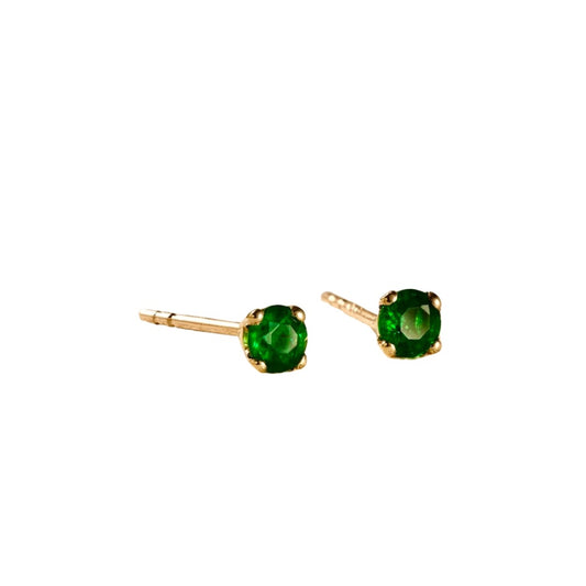Gold earrings with green gemstones on a white background