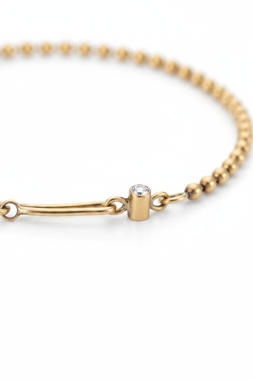 Close-up of the solid gold ball chain bracelet's handmade hook clasp set with a white diamond