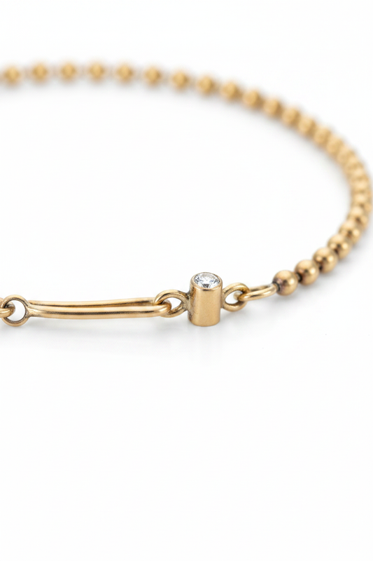 Close-up of the solid gold ball chain bracelet's handmade hook clasp set with a white diamond