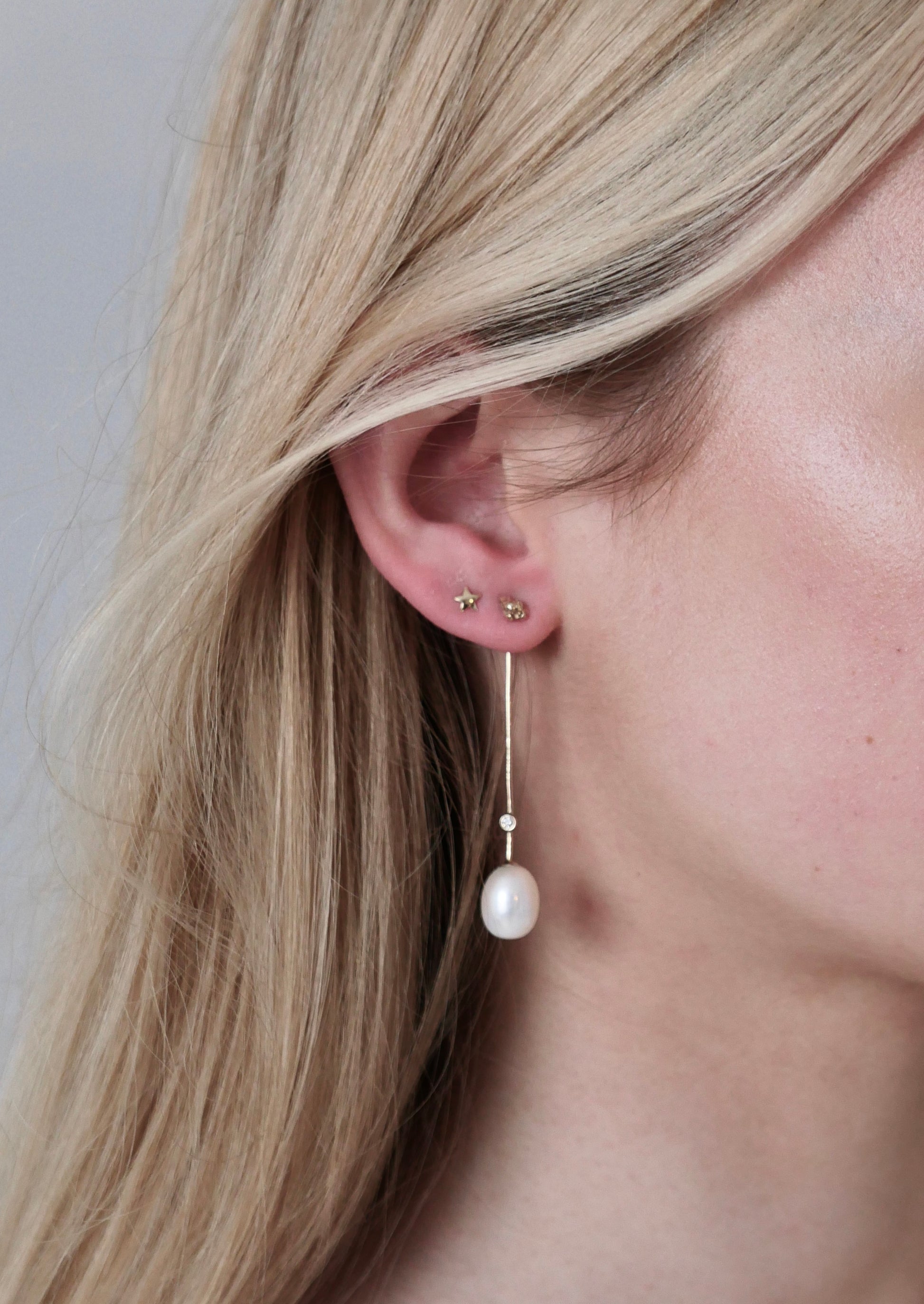 drop stem gold earrings with pearl and diamonds on model