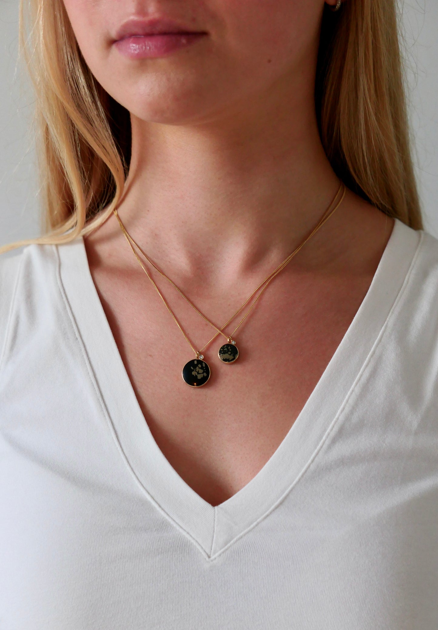black and gold slate pyrite pendant gold necklace with diamond on model with white tshirt