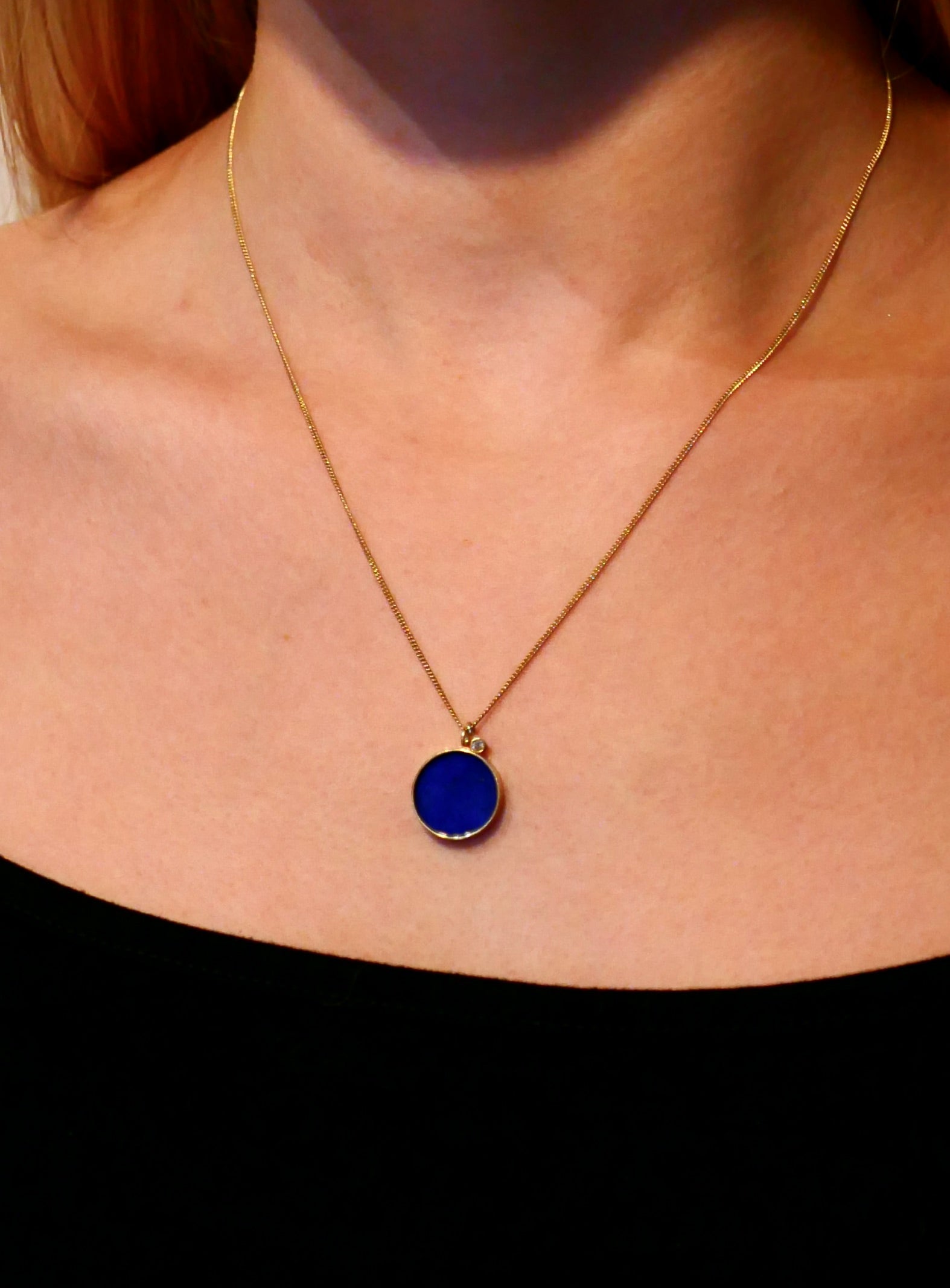 Blue lapis lazuli and gold pendant necklace on model