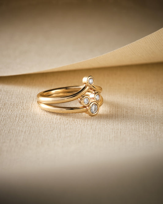 multi stone gold and diamond ring on beige background with shadow
