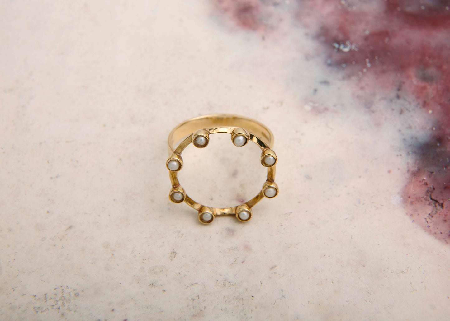 handmade pearl and gold circle ring pink marbled background front view