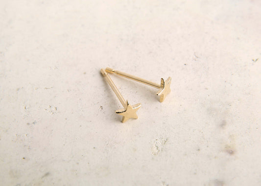 solid recycled gold star stud earrings on pink marble