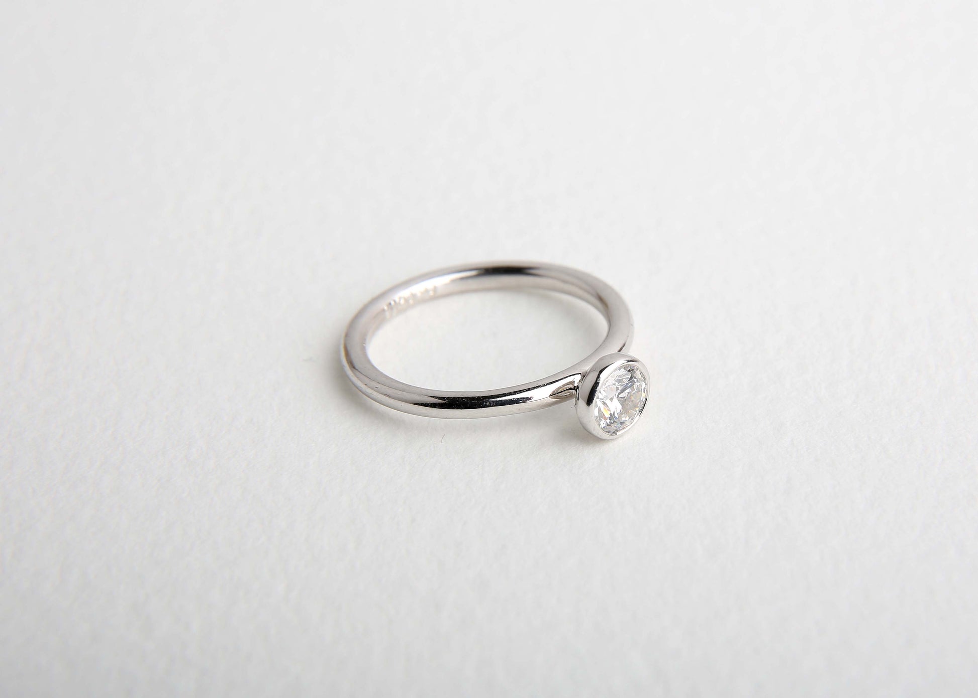 Modern diamond solitaire ring on white background