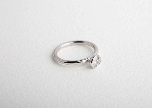 Modern diamond solitaire ring on white background