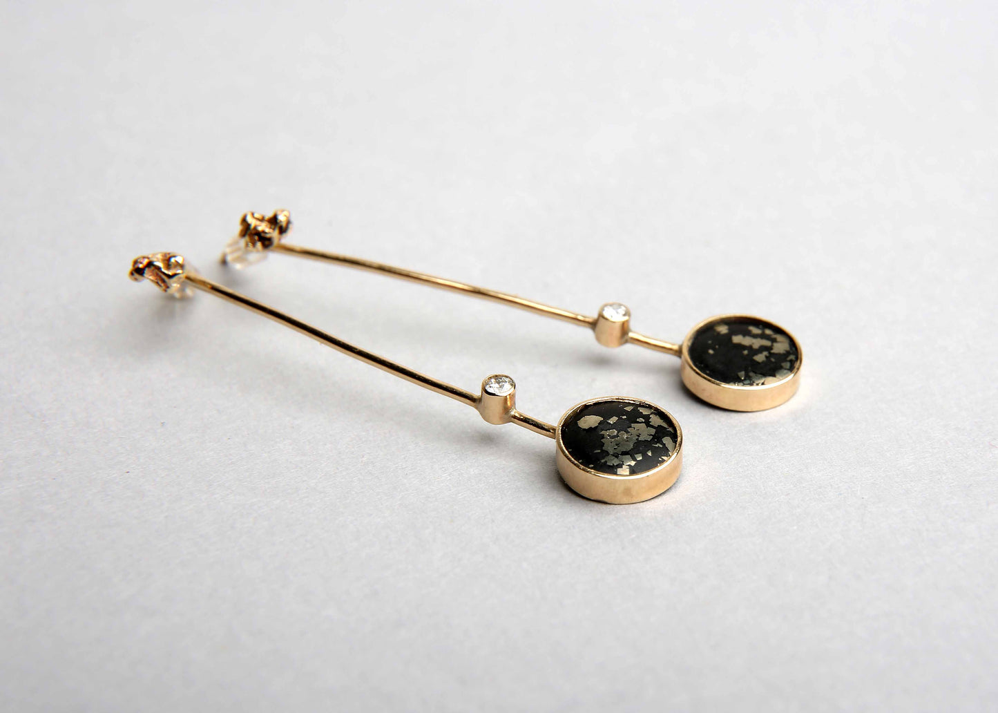 Stem black and gold drop earrings with diamond and gemstone slate pyrite on pale grey background