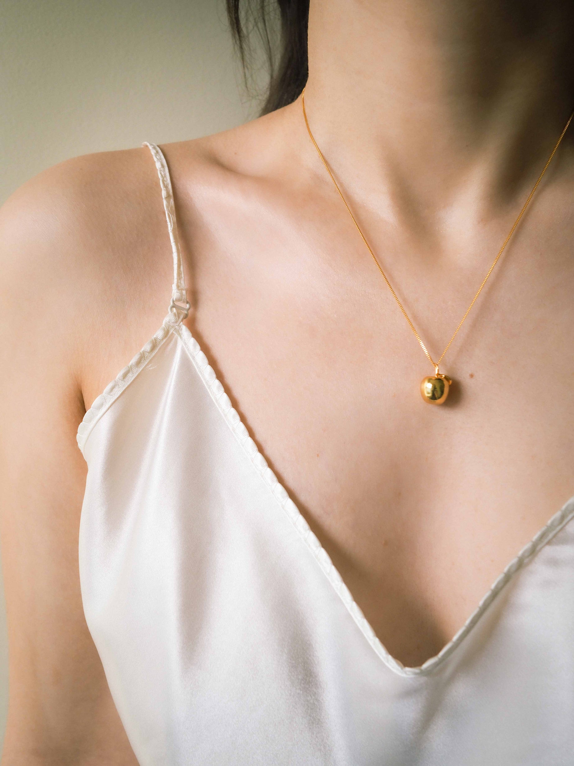 handmade gold plated apple pendant necklace on model's neck