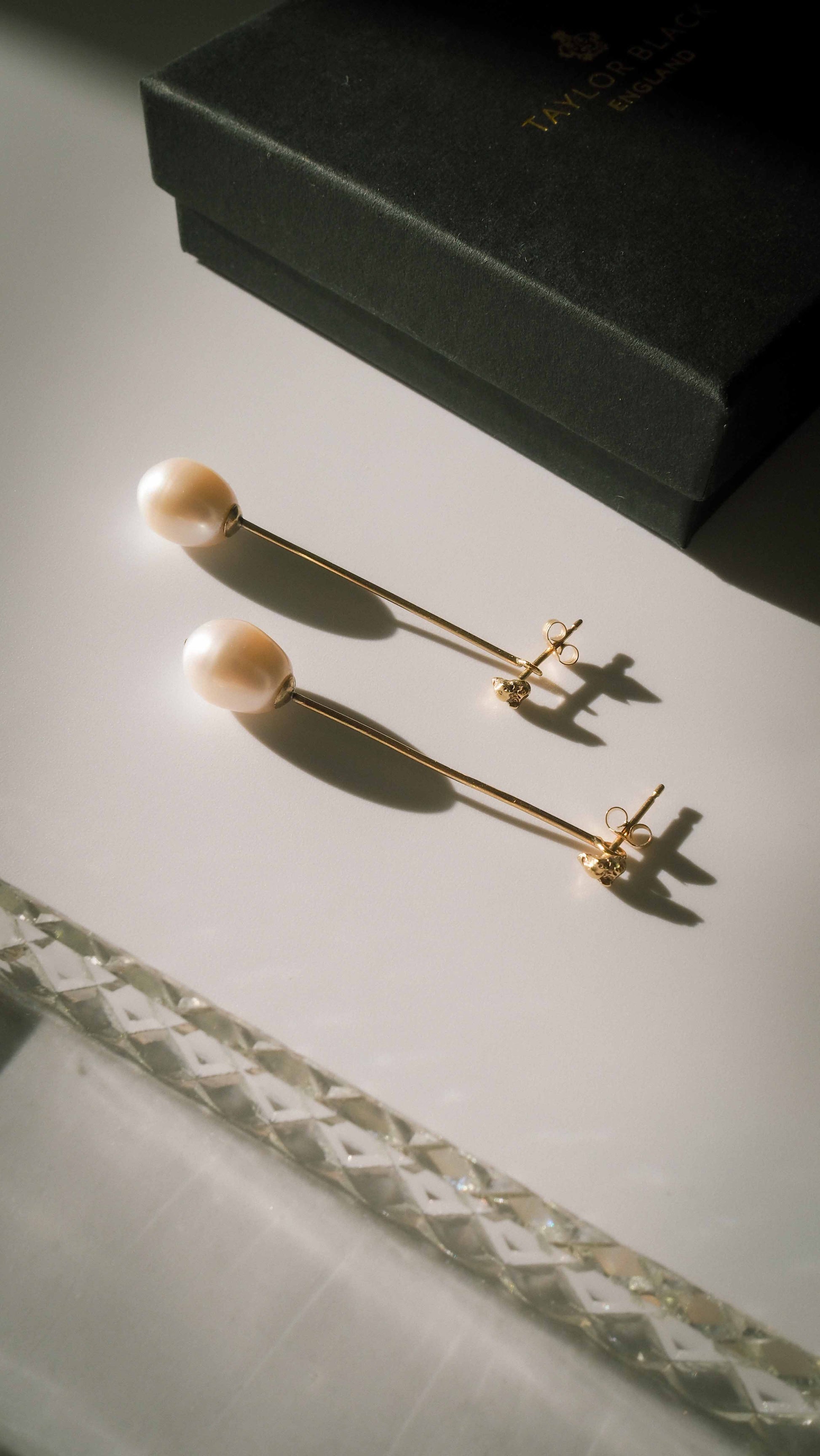 handmade drop pearl stem and gold bridal earrings on table with box 